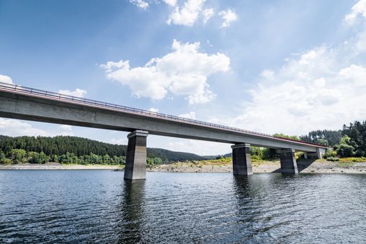 Bridge over a lake with a forest in the background in the summer