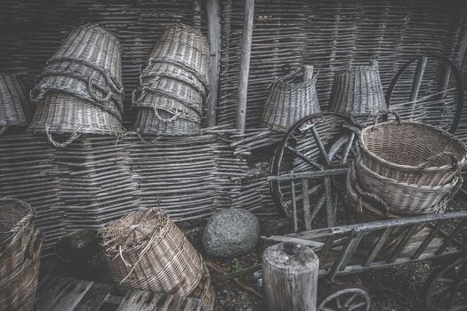 Weave baskets workshop stacked in a wooden cabin with old wheels and ladders