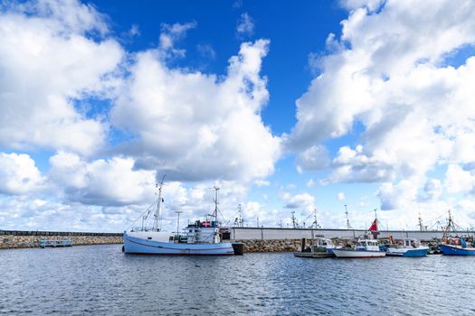 Fishing boats in a harbor in Denmark under a blue sky in the summer