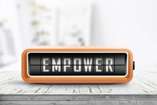 Empower message sign on a wooden desk with an orange retro device