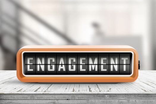 Engagement text on an orange alarm clock on a table in a hall