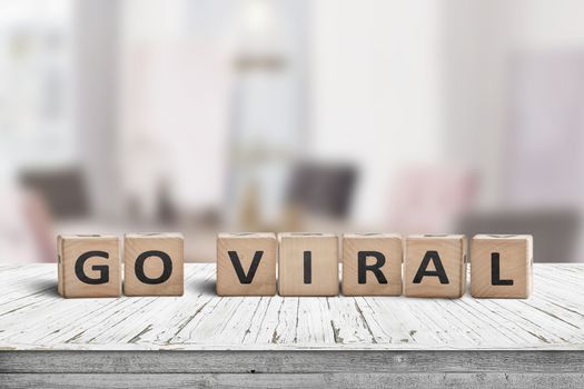 Go viral message sign on a wooden table in a bright room