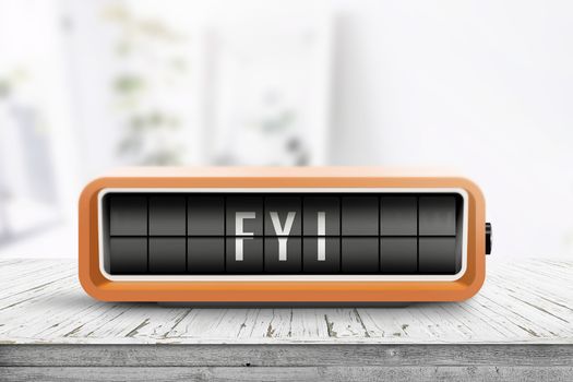 FYI message on an orange alarm clock with analog flip system on a wooden table in a bright room