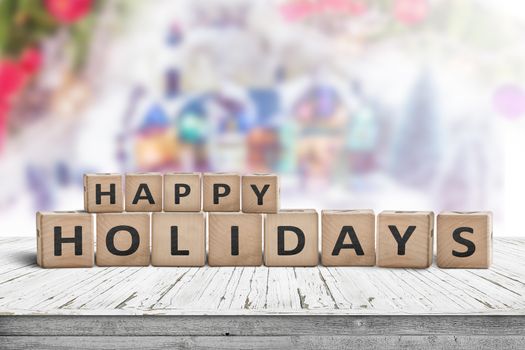 Happy Holidays sign made of wooden toy cubes with a winter landscape in the background
