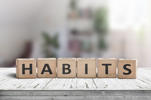 What is your habits? Sign with the word habits on a wooden desk in a bright room