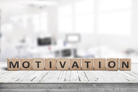 Motivation sign on a desk in a bright office in a business environment