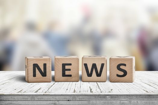 News sign on a worn wooden table with a blurry background in bright colors