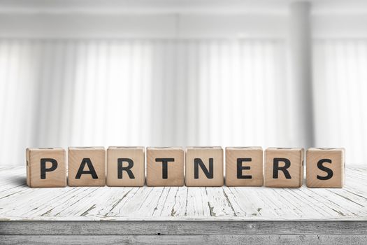 Partners sign on a desk in a bright office with white curtains in the background
