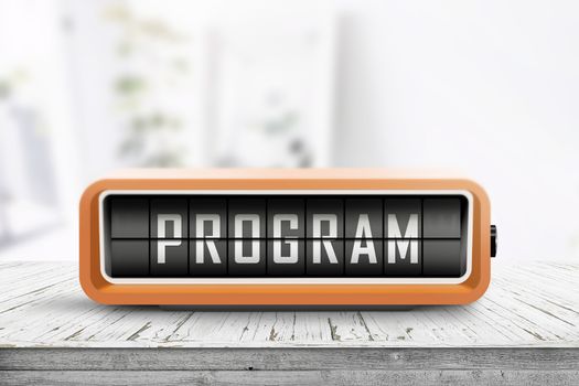 Program message on a retro clock in orange on a wooden table in bright light
