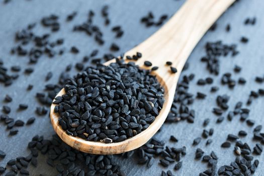 Black cumin seeds on a wooden spoon