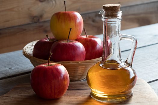 A bottle of apple cider vinegar with apples in the background
