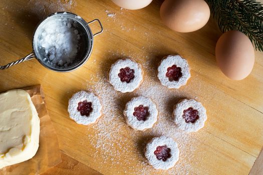 Dusting Linzer Christmas cookies with sugar on a rolling board