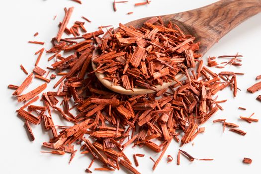 Sandalwood pieces on a wooden spoon on a white background