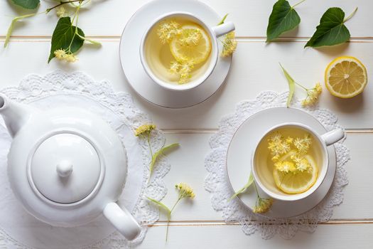 Two cups of herbal tea with linden flowers and lemon, top view