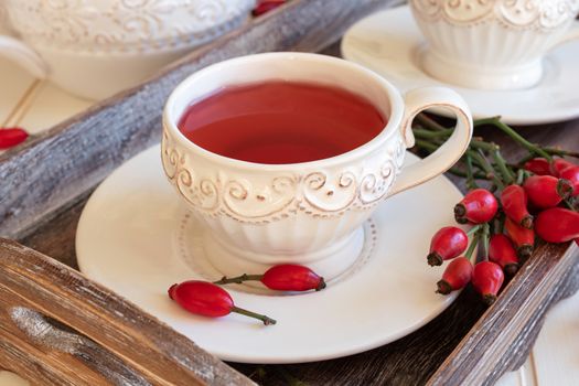 Rosehip tea in white vintage cups with fresh berries