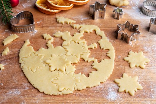 Cutting out star shapes from rolled out dough to prepare traditional Linzer Christmas cookies