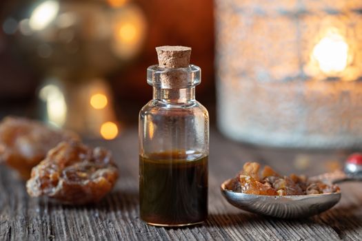 A bottle of essential oil with myrrh resin on a spoon