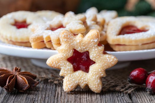 Traditional Linzer Christmas cookie filled with strawberry jam on a rustic background