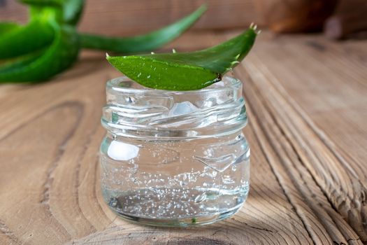 Aloe vera gel in a glass jar and fresh leaf