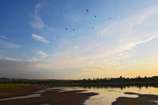 The sandy coast at the river at sunset