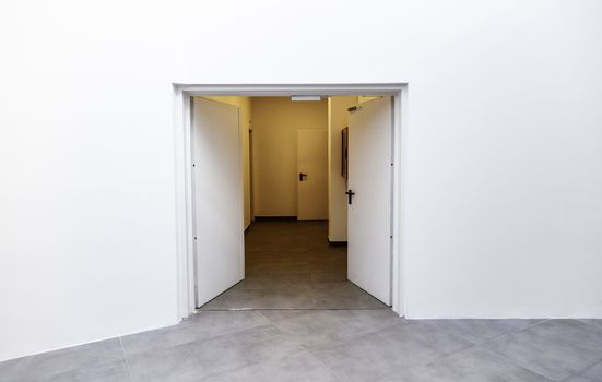 White door on a new white room, detail of the interior of a new building, modern architecture and