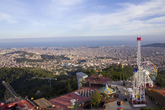 Highest viewpoint featuring an amusement park depicting views of the city and sea. Sunny day in Tibidabo, Barcelona