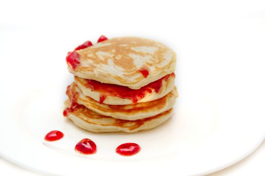 Pancakes with strawberry jam white plate. Selective focus