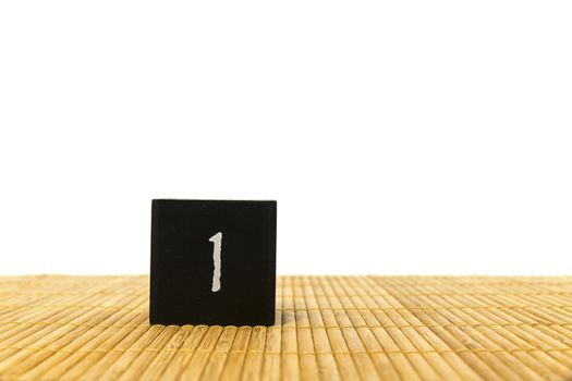 black number 1 block on bamboo underground and with isolated white background