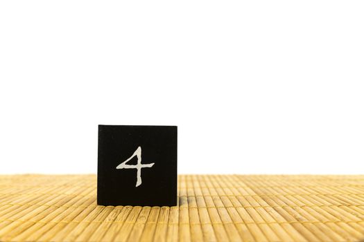 black number 4 block on bamboo underground and with isolated white background