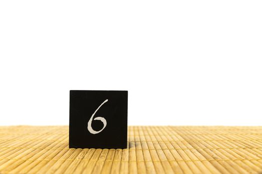 black number 6 block on bamboo underground and with isolated white background