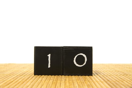 black number 10 block on bamboo underground and with isolated white background