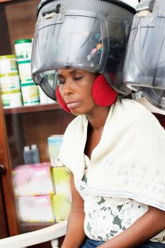 young woman placed her head under a helmet hair to dry hair