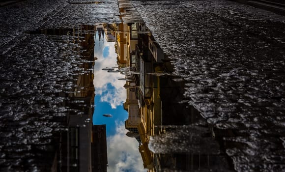Reflection of the city in a puddle on the asphalt. Reflection of the city in a puddle on the asphalt.