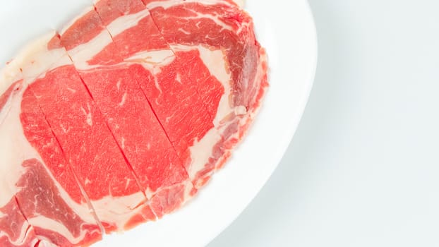 Top view of some raw beef on a plate over white background