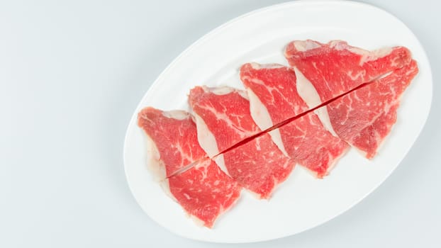 Top view of some raw beef on a plate over white background