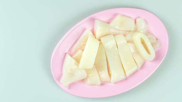 top view raw squid sliced on pink plate