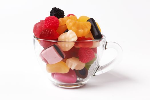 colorful candies in glass bowl on white