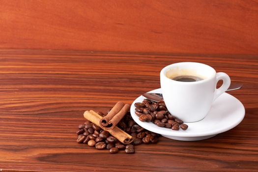  cup of coffee with coffee beans and cinnamon sticks 