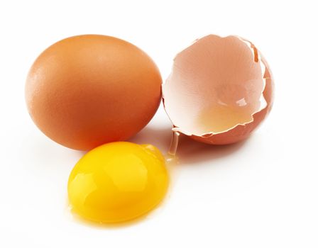 With brown eggs on a white background. One egg is broken