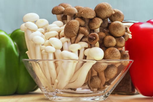 A set of sweet pepper and mushroom ingredients on a wooden boardWhite beech mushrooms or Shimeji mushroom . Small white and brown mushrooms on the table.