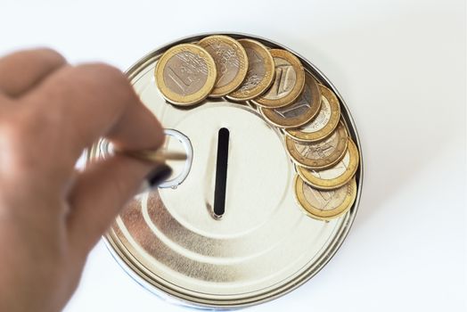 TFinancial risk and safety concept.he concept of money. A piggy bank in the form of a tin can and, next to the piggy bank, money bills and coins are laid out.