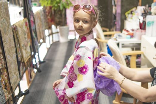 A pretty girl in a kimono. Kimono is the traditional dress worn popular in Japan.European girl in kimono.Portrait of girl wearing japanese traditional kimono .