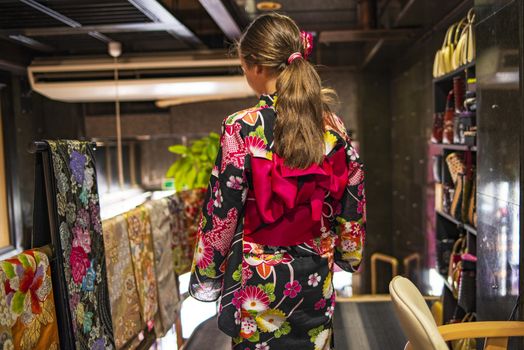A pretty girl in a kimono. Kimono is the traditional dress worn popular in Japan.European girl in kimono.Portrait of girl wearing japanese traditional kimono .