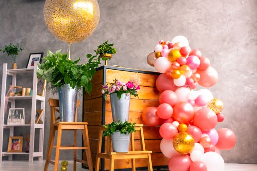 On the wooden surface laid out tools for flower bouquets: scissors, roses, colored ribbon, roses.