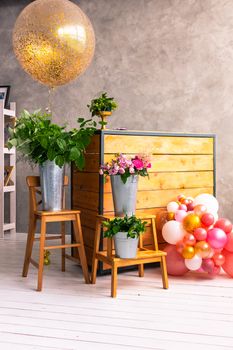 On the wooden surface laid out tools for flower bouquets: scissors, roses, colored ribbon, roses.