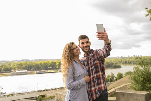 Happy lovers in moments of happiness taking a selfie photos and enjoying the time in nature