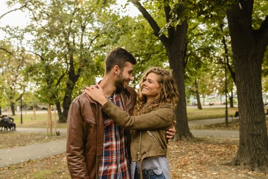 Happy stylish couple in love hugging each other in summer park in the city. Romantic moment