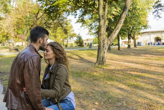 Attractive and modern lovers showing sweetest emotions in the public park