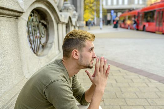 Stressed man is praying to the God and hoping for better times to come