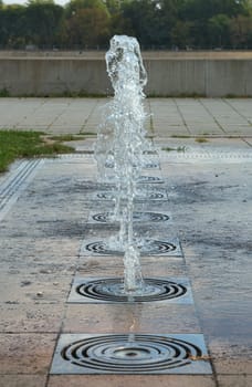 Several small ground fountains in one line